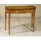 Elegante tavolo da gioco in satinwood, il piano con gli angoli arrotondati presenta una fascia in palissandro in corrispondenza del bordo esterno. La fascia sottostante presenta un pannellino centrale con un intarsio a forma di diamante. Le quattro gambe squadrate e rastremate.
Inghilterra, periodo Sheraton, c.1790.
Dimensioni: L. cm 92; P. cm 42; A. cm 73.5